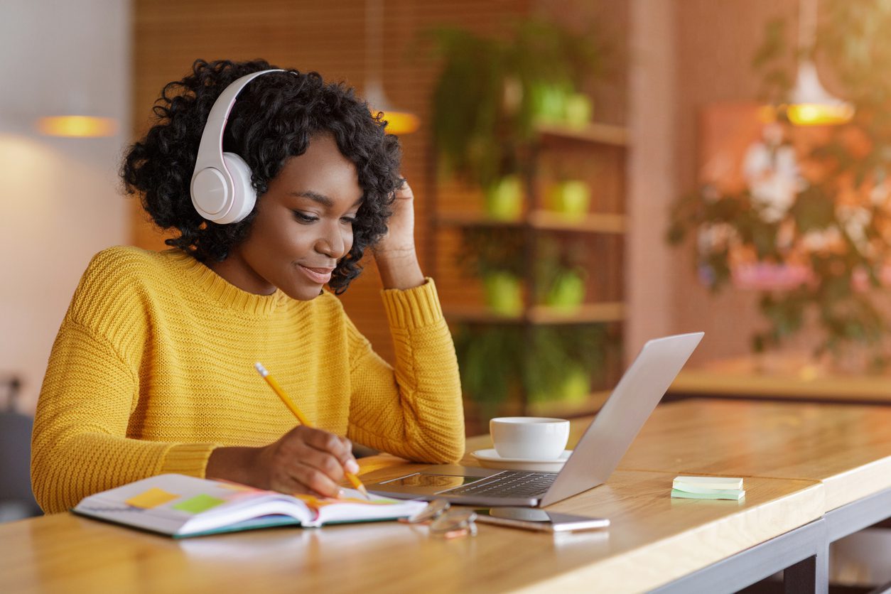 Smiling black girl with headset studying online