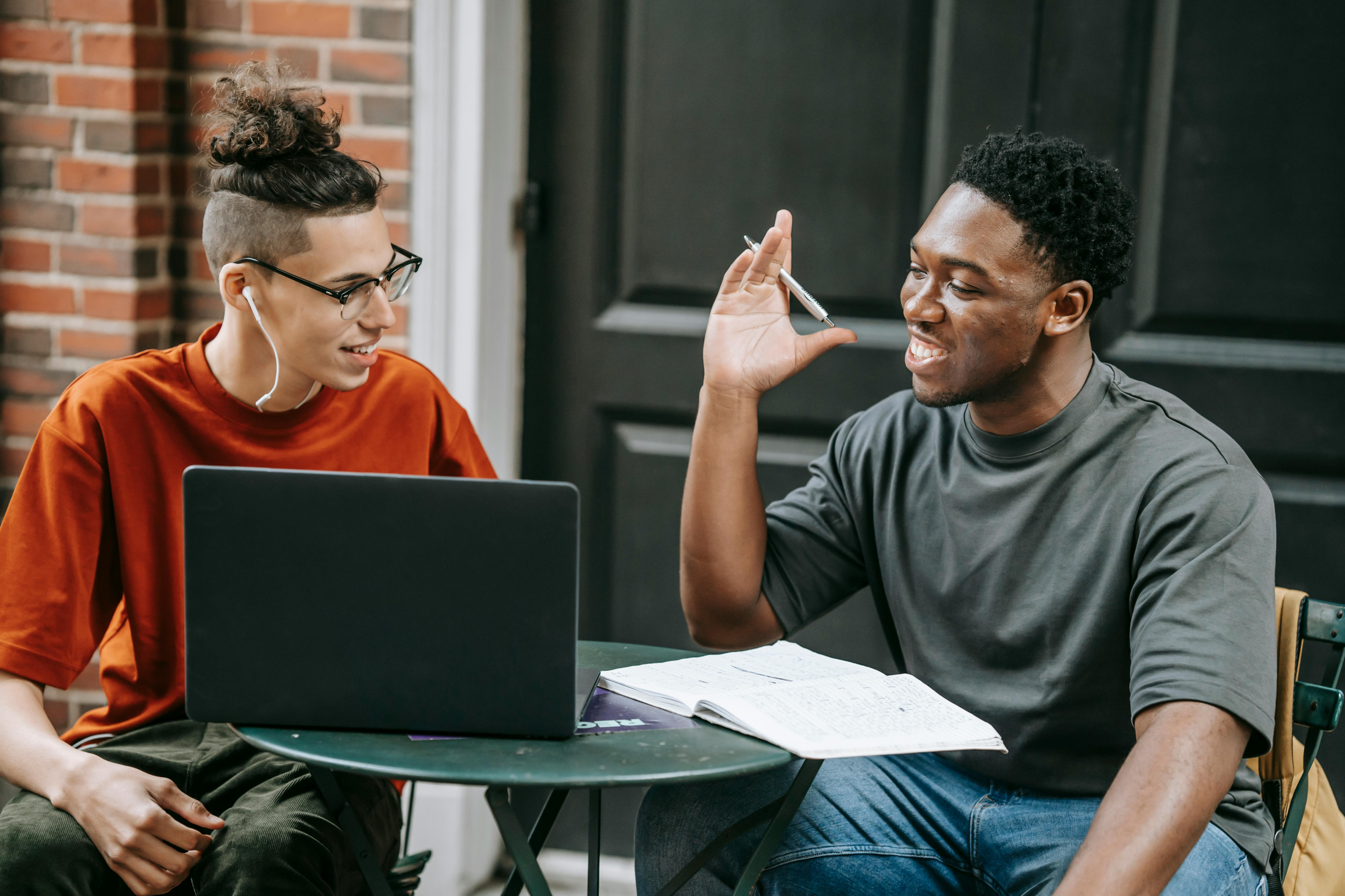 Two people collaborating at a table outside