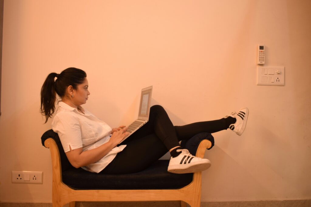 Woman lounging on a chair using a laptop