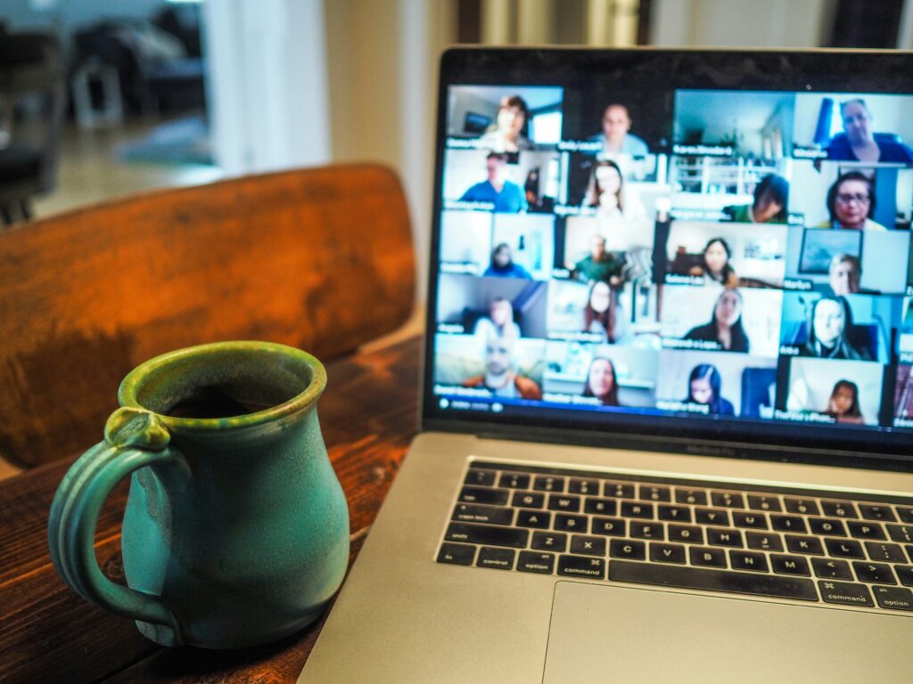 MacBook Pro running a Zoom call with a coffee cup beside it 