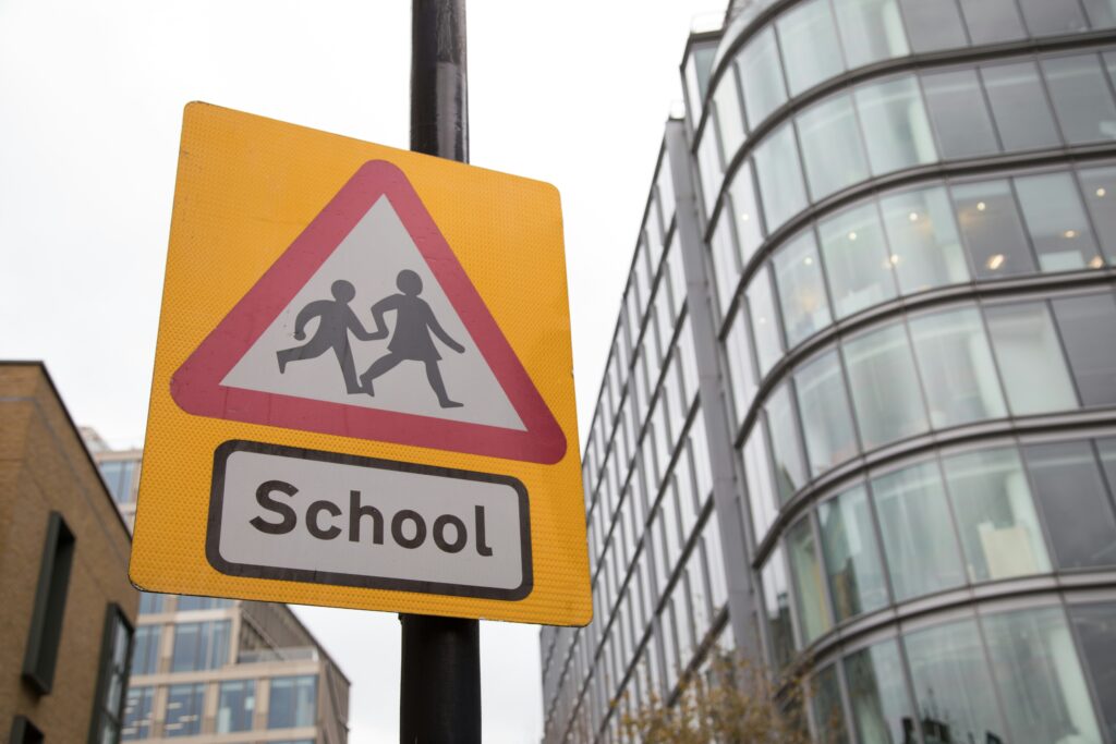 A school crossing sign in front of a building