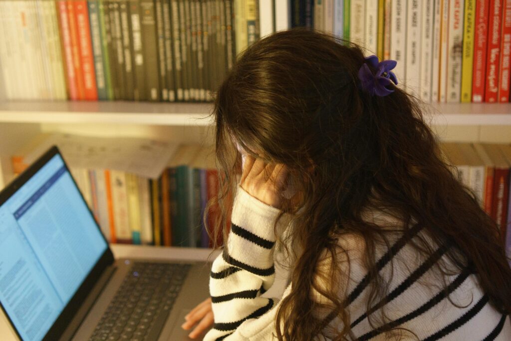 Student studying on a laptop looking stressed