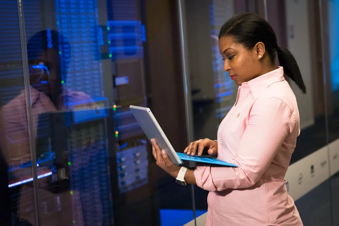 Software engineer working on a laptop in a server room